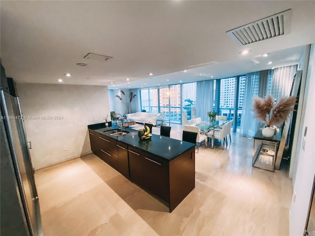 kitchen with floor to ceiling windows, sink, and dark brown cabinets