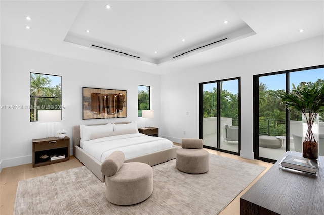 bedroom featuring baseboards, a raised ceiling, access to outside, light wood-type flooring, and recessed lighting