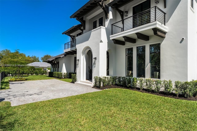 7001 SW 71st Ave, Miami, FL 33143 - entrance to property featuring a balcony, stucco siding, and a lawn