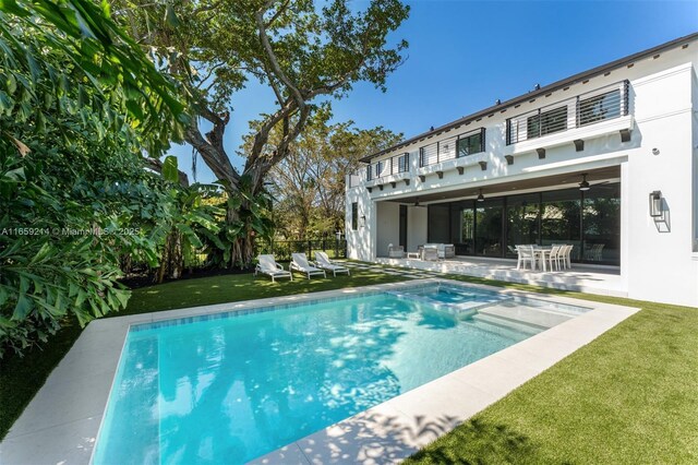 7001 SW 71st Ave, Miami, FL 33143 - rear view of house featuring a balcony, a patio area, a pool with connected hot tub, a ceiling fan, and stucco siding