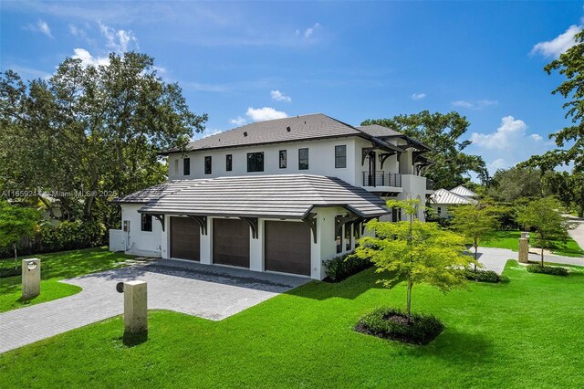 7001 SW 71st Ave, Miami, FL 33143 - rear view of house with a balcony, an attached garage, a lawn, driveway, and stucco siding