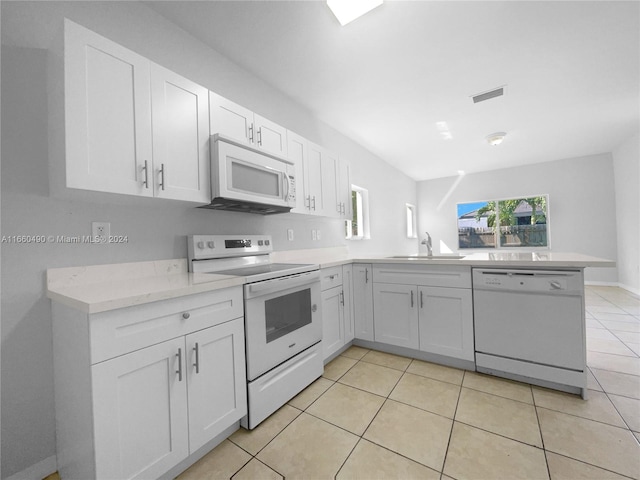 kitchen with white appliances, sink, kitchen peninsula, and white cabinets