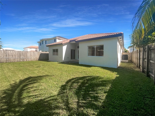 rear view of house with a yard and central air condition unit