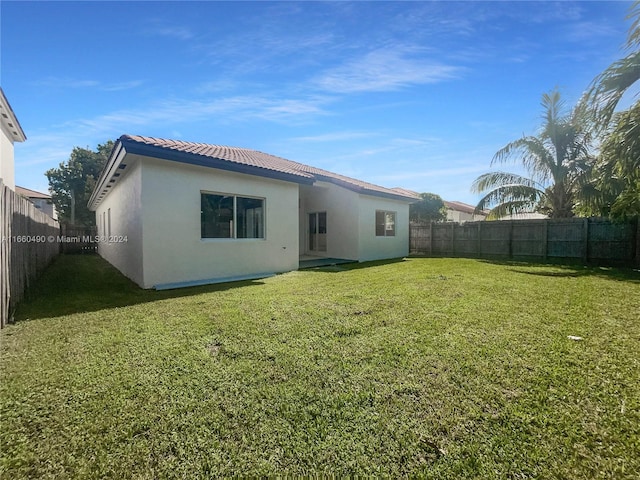 rear view of property with a yard