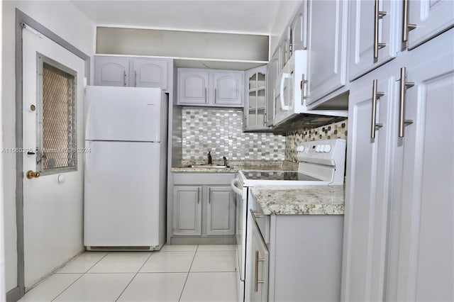 kitchen featuring decorative backsplash, sink, light tile patterned floors, gray cabinets, and white appliances