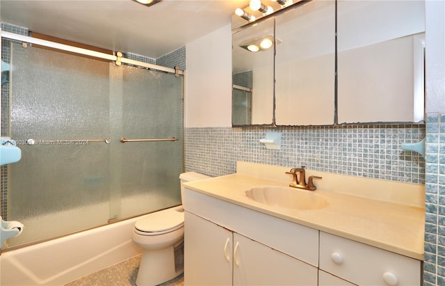 full bathroom with tile walls, vanity, enclosed tub / shower combo, and toilet