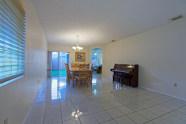 dining space featuring plenty of natural light, visible vents, arched walkways, and a chandelier