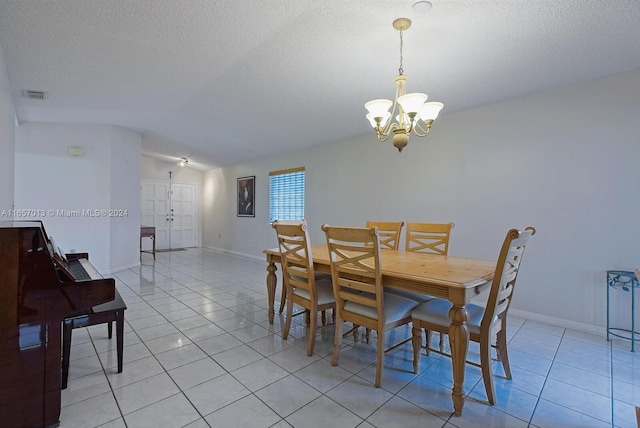 tiled dining space with a textured ceiling, vaulted ceiling, and a chandelier