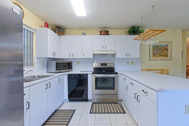 kitchen with appliances with stainless steel finishes, kitchen peninsula, light tile patterned floors, and white cabinets