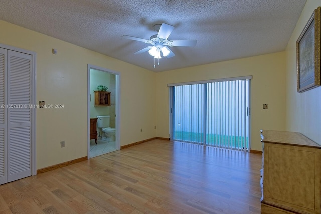 empty room featuring a ceiling fan, light wood-style floors, and a textured ceiling