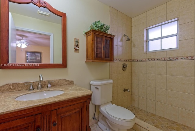 bathroom featuring visible vents, a tile shower, toilet, a ceiling fan, and vanity