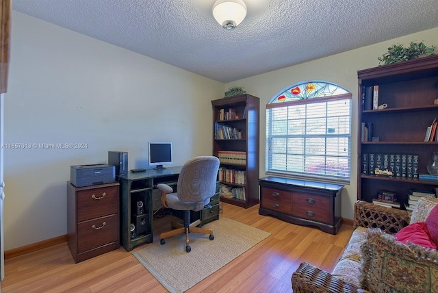 home office with a textured ceiling and light hardwood / wood-style floors