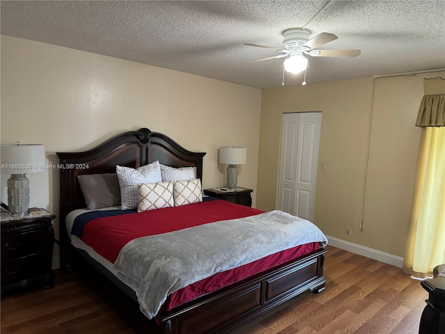 bedroom with ceiling fan, a textured ceiling, a closet, and dark hardwood / wood-style floors