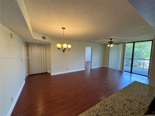 spare room featuring ceiling fan with notable chandelier, floor to ceiling windows, a textured ceiling, and dark hardwood / wood-style floors