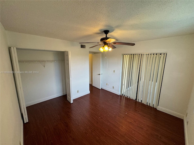 unfurnished bedroom featuring ceiling fan, a textured ceiling, a closet, and dark hardwood / wood-style floors