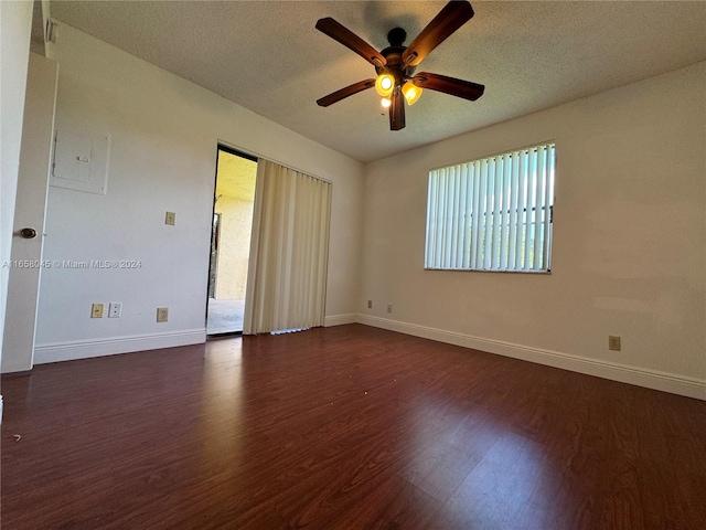 spare room with ceiling fan, a textured ceiling, dark hardwood / wood-style floors, and a wealth of natural light