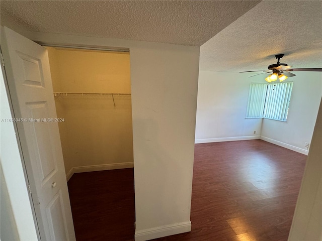 spacious closet with ceiling fan and dark hardwood / wood-style flooring