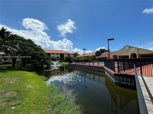 dock area featuring a lawn and a water view