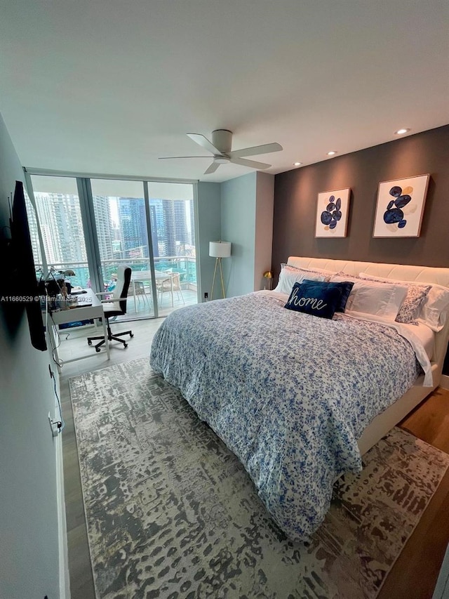 bedroom with recessed lighting, a ceiling fan, wood finished floors, a wall of windows, and access to outside