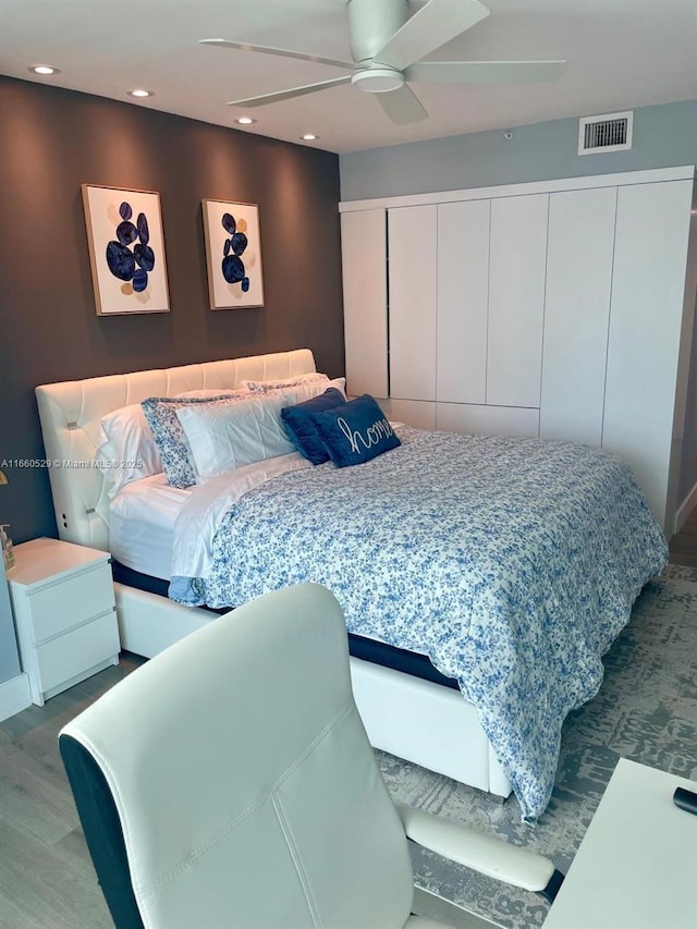 bedroom with a ceiling fan, recessed lighting, visible vents, and wood finished floors