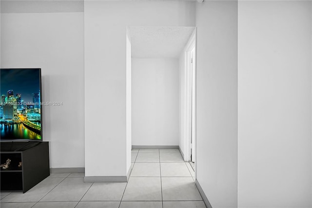 hall with light tile patterned floors and a textured ceiling