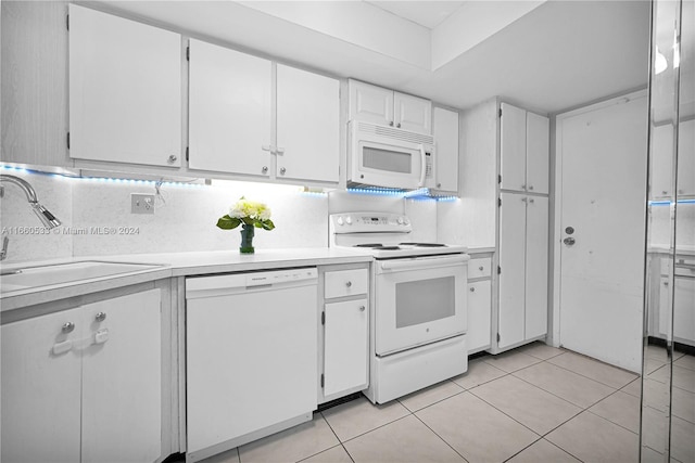 kitchen featuring backsplash, white appliances, sink, white cabinetry, and light tile patterned flooring