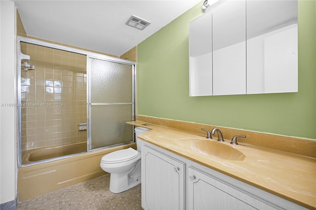 full bathroom featuring vanity, enclosed tub / shower combo, and toilet