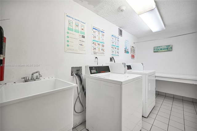 laundry room featuring sink, a textured ceiling, separate washer and dryer, and light tile patterned flooring