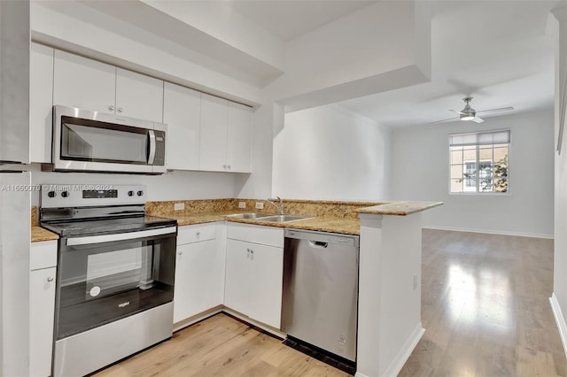 kitchen featuring white cabinets, stainless steel appliances, kitchen peninsula, and light hardwood / wood-style flooring