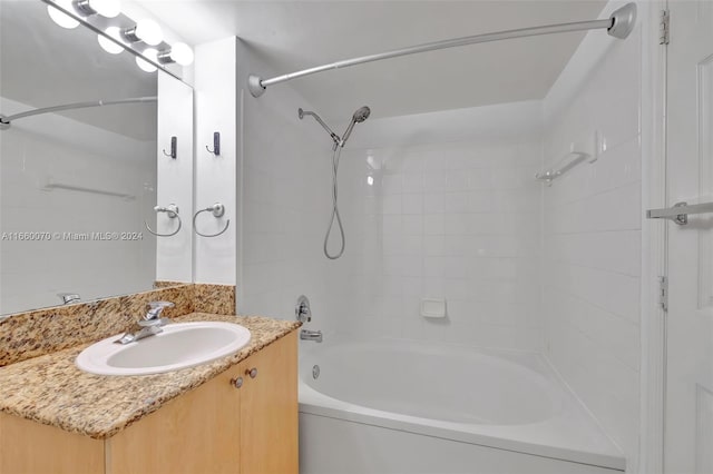 bathroom featuring tiled shower / bath and vanity