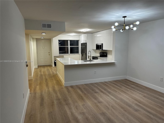 kitchen with black appliances, sink, white cabinetry, and kitchen peninsula