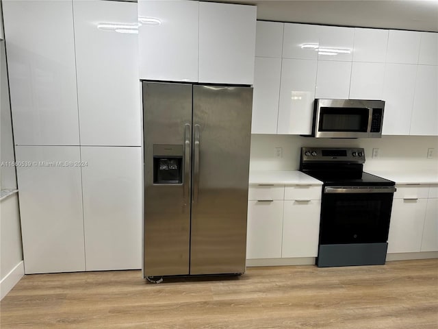 kitchen featuring white cabinets, stainless steel appliances, and light hardwood / wood-style flooring