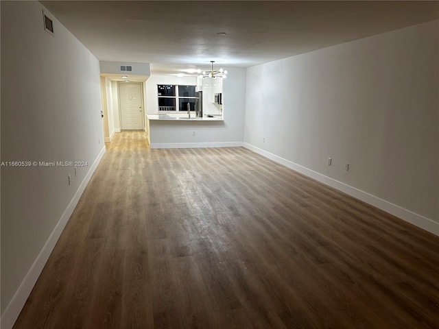 unfurnished living room with a chandelier, sink, and wood-type flooring