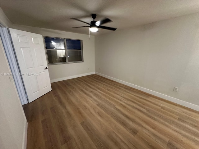 unfurnished bedroom featuring hardwood / wood-style floors, ceiling fan, and a textured ceiling