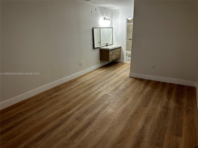 unfurnished bedroom featuring hardwood / wood-style floors and sink