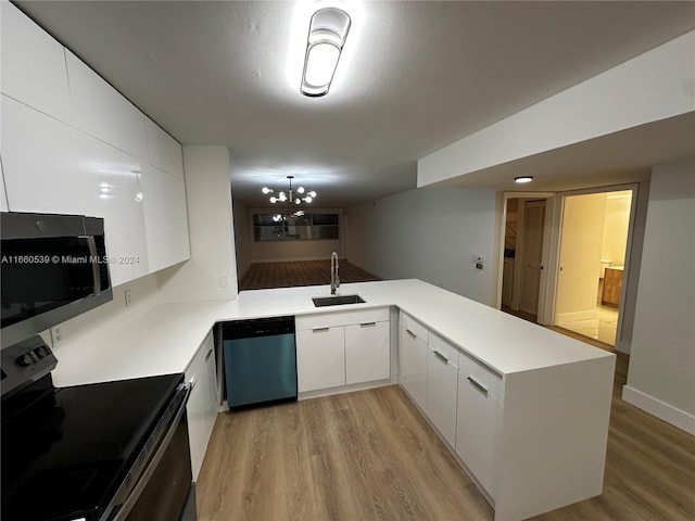 kitchen featuring white cabinets, sink, light hardwood / wood-style floors, kitchen peninsula, and stainless steel appliances