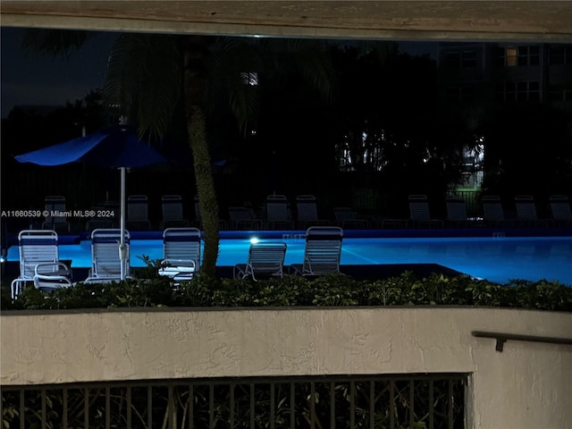 view of pool at twilight