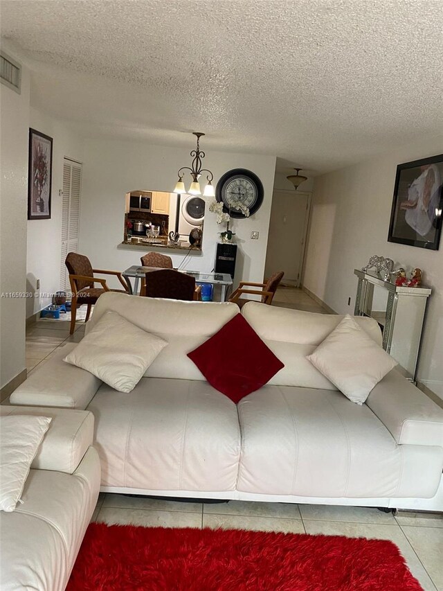 living room featuring a textured ceiling and a chandelier