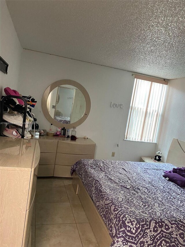 tiled bedroom with a textured ceiling