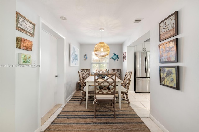 dining space featuring light tile patterned floors and a chandelier