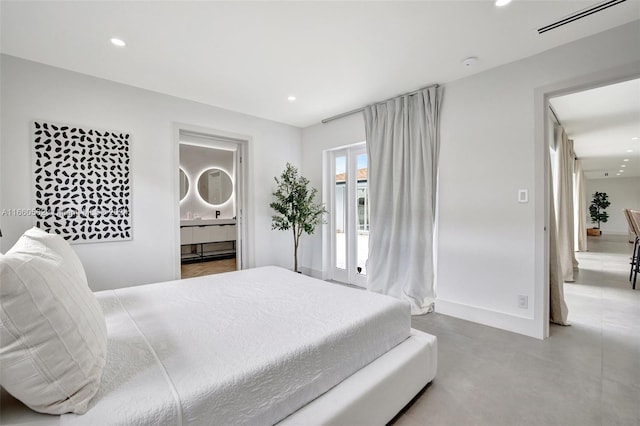 bedroom with ensuite bath and concrete flooring