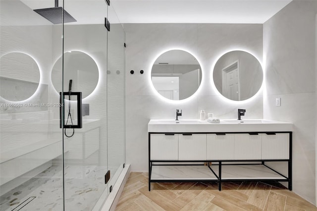 bathroom with a shower with shower door, vanity, and parquet flooring