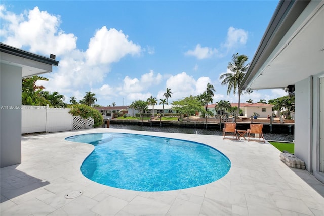 view of swimming pool with a water view and a patio area