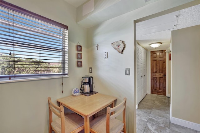 tiled dining space with a textured ceiling