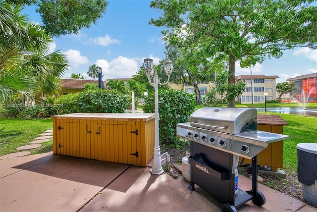 view of patio featuring a water view and a grill