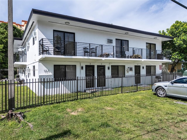 view of front of house with a balcony and a front lawn