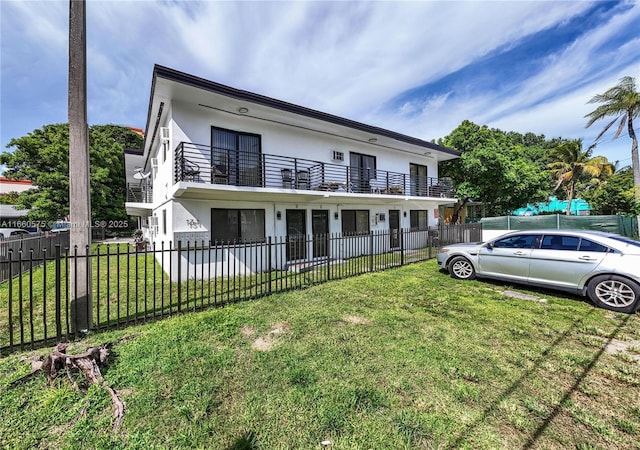 view of front of house with a balcony and a front lawn