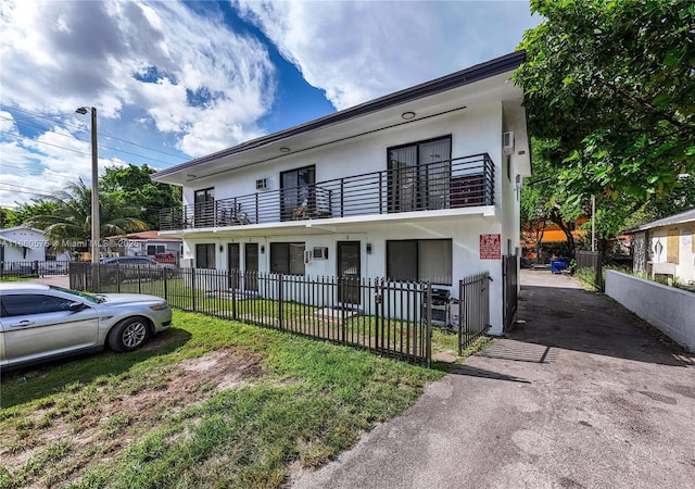 view of front of home featuring a balcony and a front yard