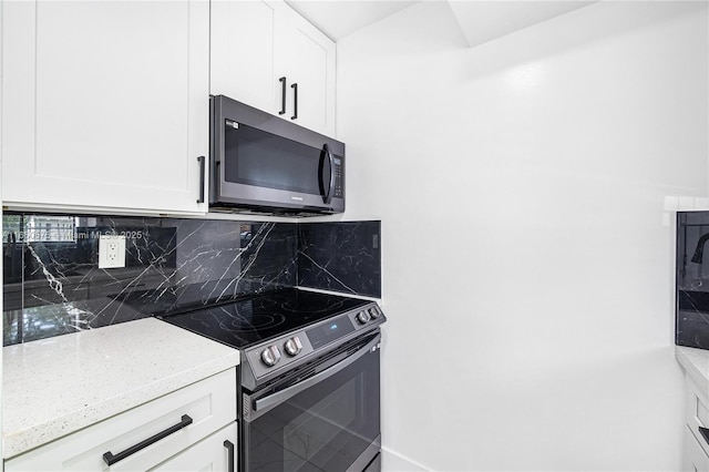 kitchen featuring tasteful backsplash, appliances with stainless steel finishes, light stone counters, and white cabinets