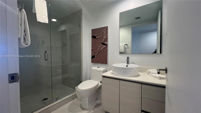 bathroom with vanity, tile patterned flooring, toilet, and an enclosed shower